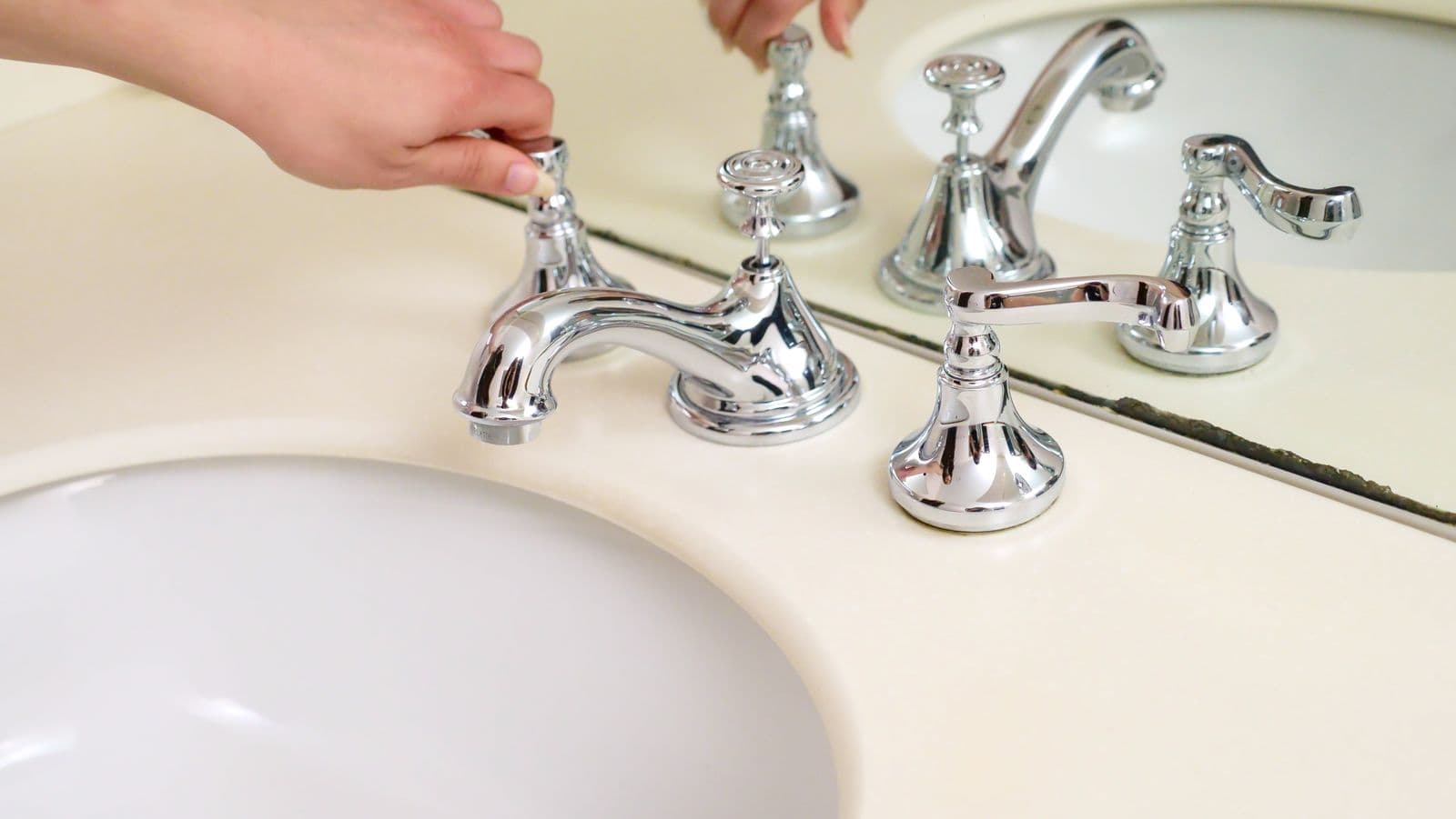 Hands installing a new bathroom faucet