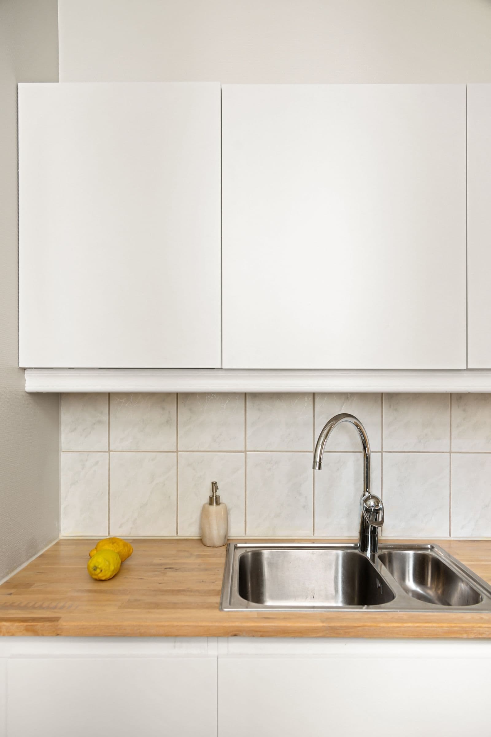 Bright kitchen with a stainless sink and gooseneck faucet