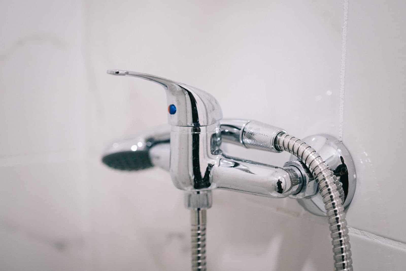 Chrome wall-mounted shower mixer valve with a hand shower